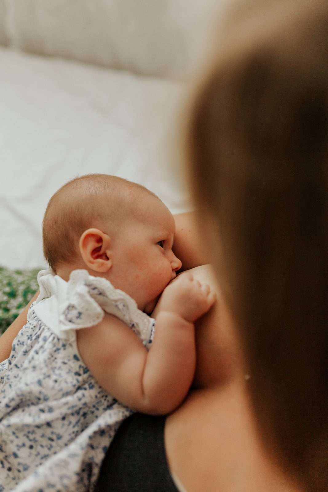 Baby die borstvoeding krijgt, tegen mama aan